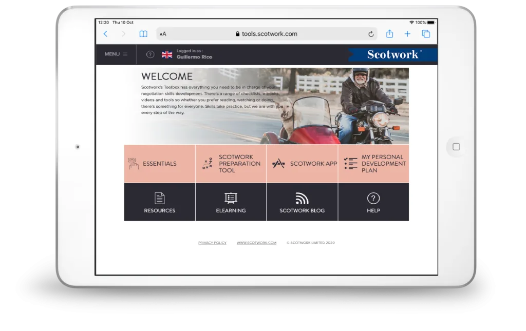 A tablet displays a webpage titled Welcome from Scotwork Toolbox, featuring navigation buttons and a banner image of a person riding a motorcycle with a sidecar, both riders wearing helmets and jackets.

