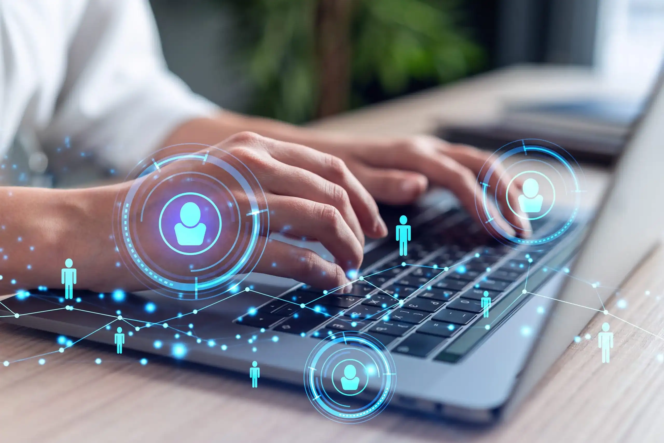A person types on a laptop keyboard, with digital network icons of people and connection lines overlaid, symbolizing digital communication or online networking.