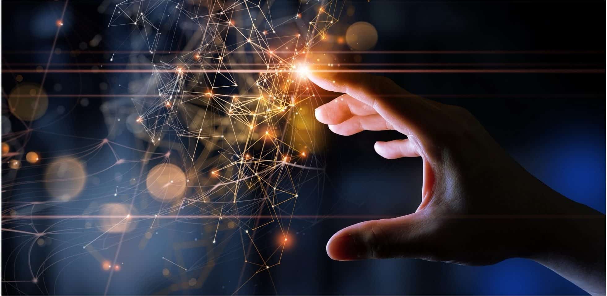 A hand reaches out to touch a glowing network of interconnected points and lines, symbolizing digital technology, connectivity, or data interaction, with a dark and blurred background.