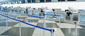 Empty airport check-in counters with blue queue barriers