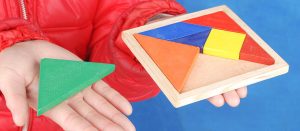 Hands arranging pieces of a traditional Chinese puzzle