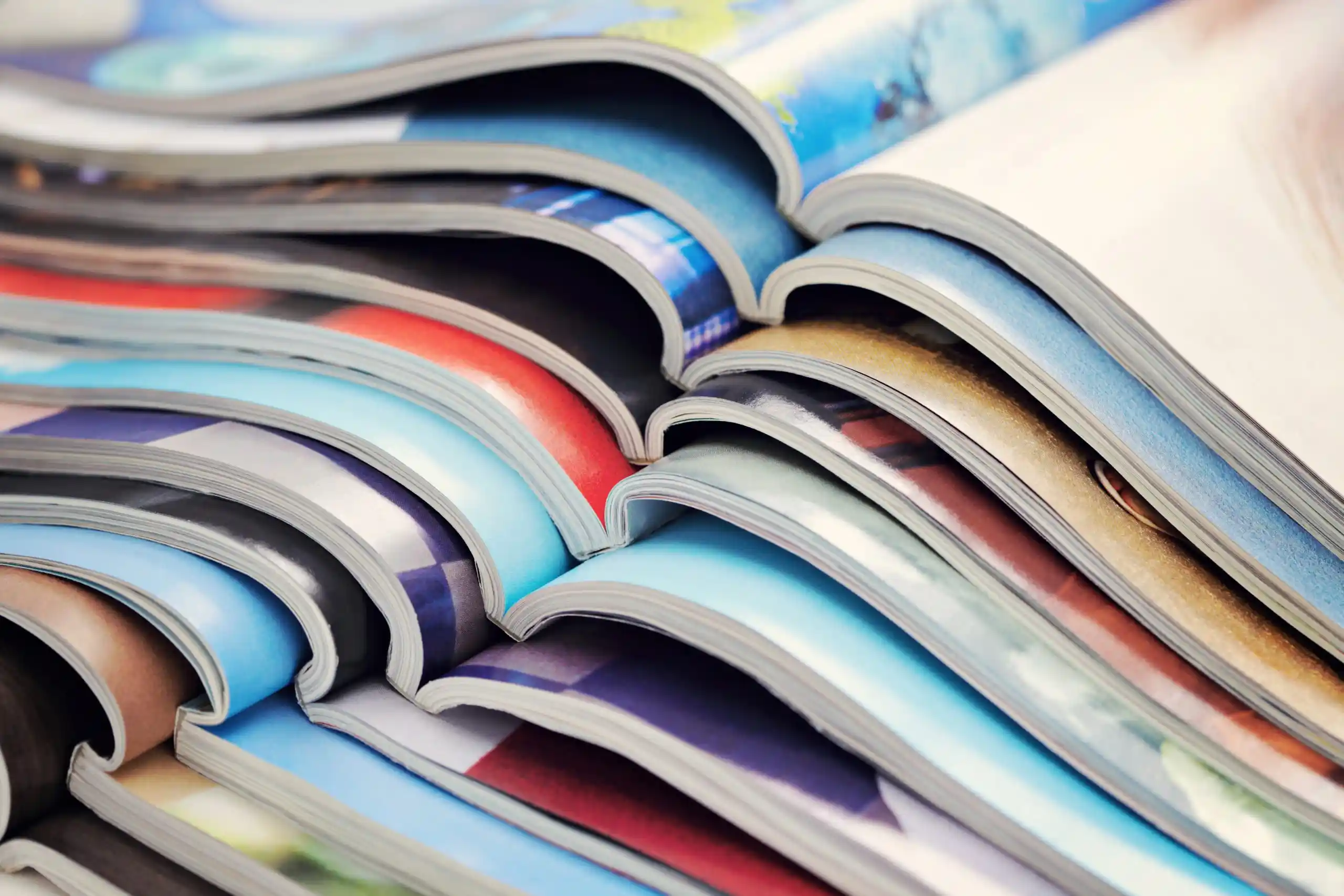 A stack of colorful magazines with various covers displayed.