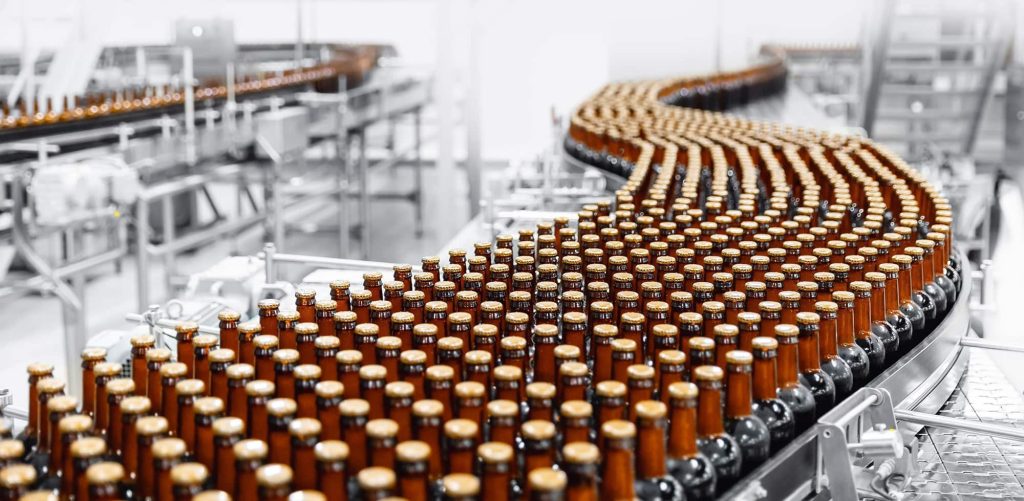 Rows of brown glass bottles moving along an automated production line