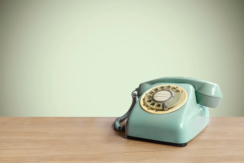 Green rotary telephone on a desk